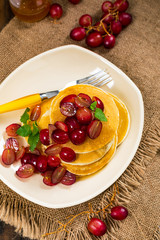 Healthy Homemade Classic American Pancakes with Sliced Red Grapes and Maple Syrup Close Up. Selective focus.