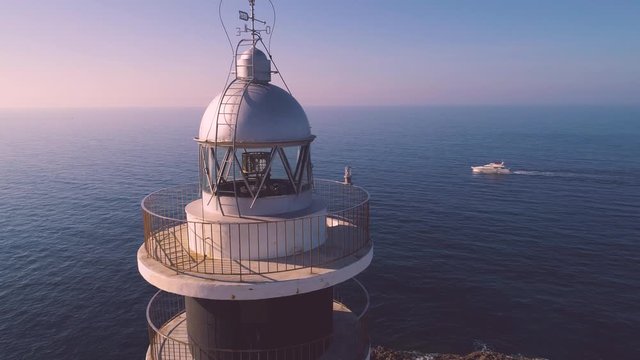 Lighthouse on rocky seashore with curved road
