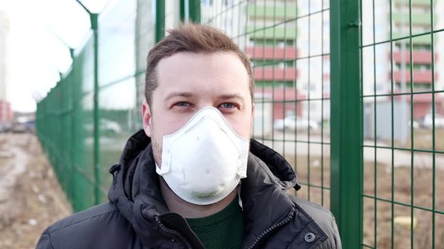 Man in the medical mask in empty city street. Pandemic and epidemic. European man standing near state border. Prohibition of entry and exit into the country.
