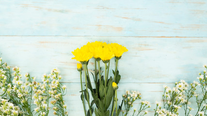 Daisy flowers with green stem on wooden background
