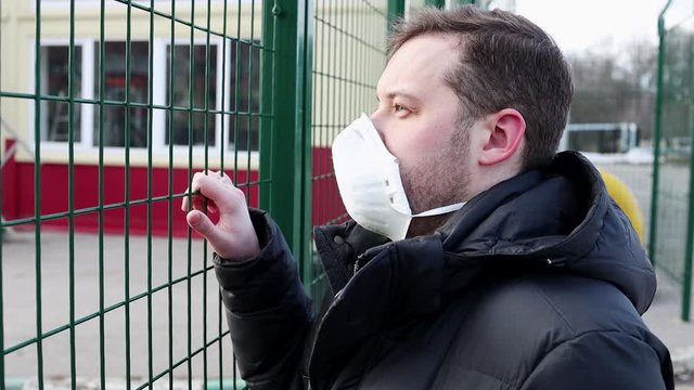 Man in the medical mask in empty city street. Pandemic and epidemic. European man standing near state border. Prohibition of entry and exit into the country.
