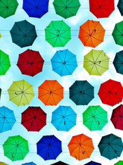 Group of umbrellas hanging on a rope isolated against blue background