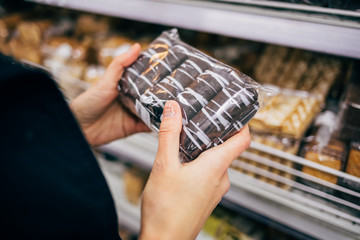 Close-up young woman holding pack of chocolate cookies