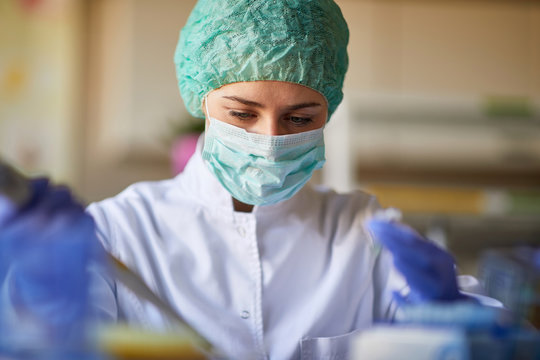 Woman in lab with protective gear working
