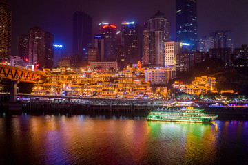 Fototapeta na wymiar Aerial view of Hong Ya dong Cave, Historic Chinese folk religion town with lights on by Jialing River with skyscraper