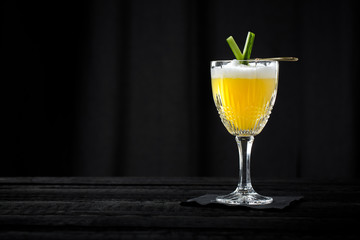 vintage style sour cocktail with egg white foam on black background