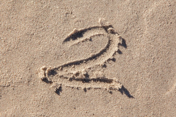2 written on beach sand