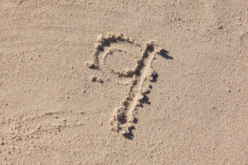 9 written on beach sand