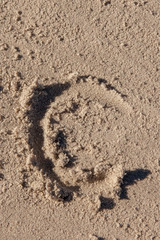 the letter c written in beach sand