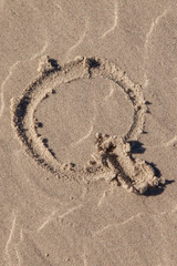 the letter q written in beach sand