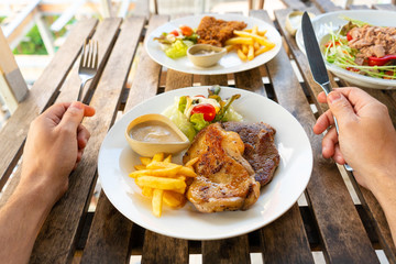First-person view of a guy eating food in a summer cafe.