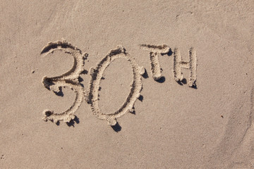 thirtieth written in beach sand