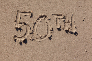 fiftieth written in beach sand