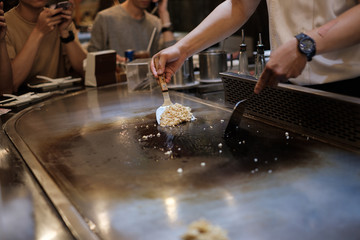 He stir fry food in a flat pan. cook tools and flat pad teppanyaki japanese food