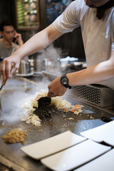 He stir fry food in a flat pan. cook tools and flat pad teppanyaki japanese food