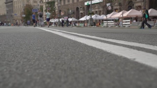 Road marking double line city street unrecognizable pedestrians camera movement slow motion