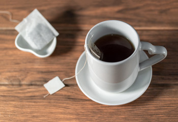 una taza de té caliente con una bolsa de té en una mesa de madera