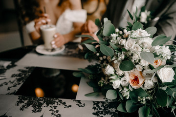 Couple in love holding hands with coffee on white wooden table. Photograph taken from above, top view with copy space