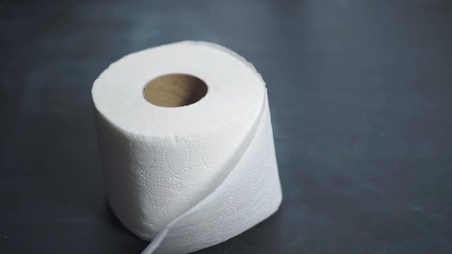 A roll of toilet paper slowly falls onto the table. Toilet paper shortages during a crisis and pandemic. The financial crisis 2020.