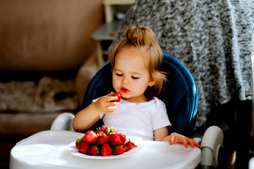 little girl eating strawberries at home