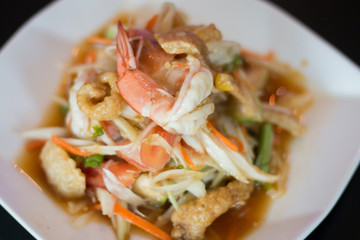 Thai papaya salad with fresh shrimp and crispy pork skin, a popular food for Thai people