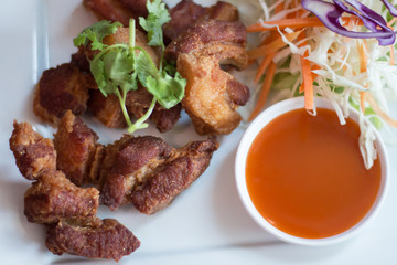 Deep fried pork belly served with sauce and salad