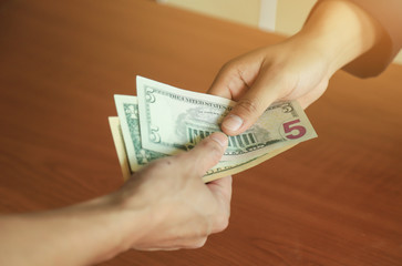 hand giving hand and taking dollar money change  in business concept 