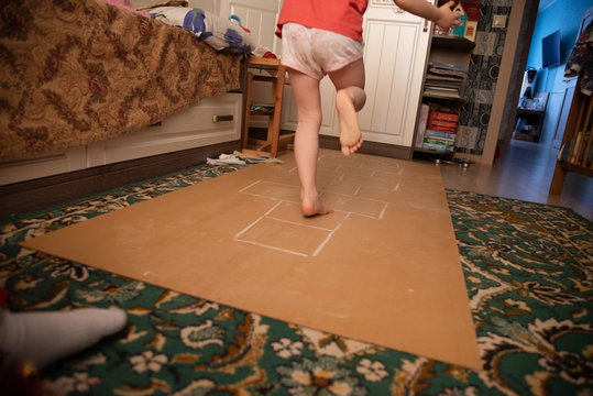 Child Playing Hopscotch Inside At Her Home Healthy Body Lifestyle Concept, Side View. What To Do In Quarantine. Street Entertainment In The House During Self-isolation