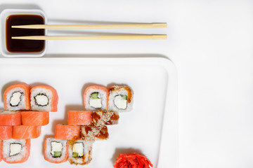 Sushi rolls set philadelphia on a white ceramic plate on a white background.