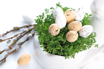 Easter holiday table decoration - eggs in green cress leaves and willow catkins