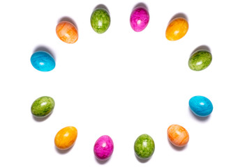 Circle of easter eggs in different colors on white background