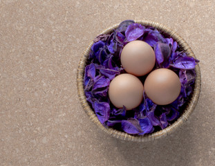 Cestita con tres huevos en mesa de corcho