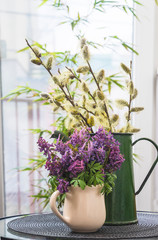 Spring still life with bouquet of corydalis flowers and willow in bloom in vintage jug. Vertical picture