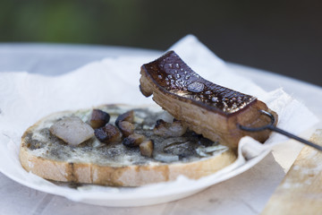 Speck auf dem Spiess und auf dem Brot in einem Teller