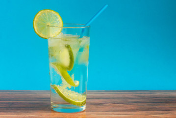 Fresh mineral water soft drink with lime slices in a glass cup.
