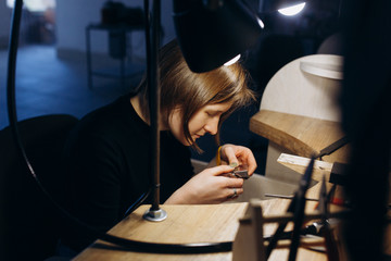 Woman artist making silver jewelry in her workshop, unusual hobby