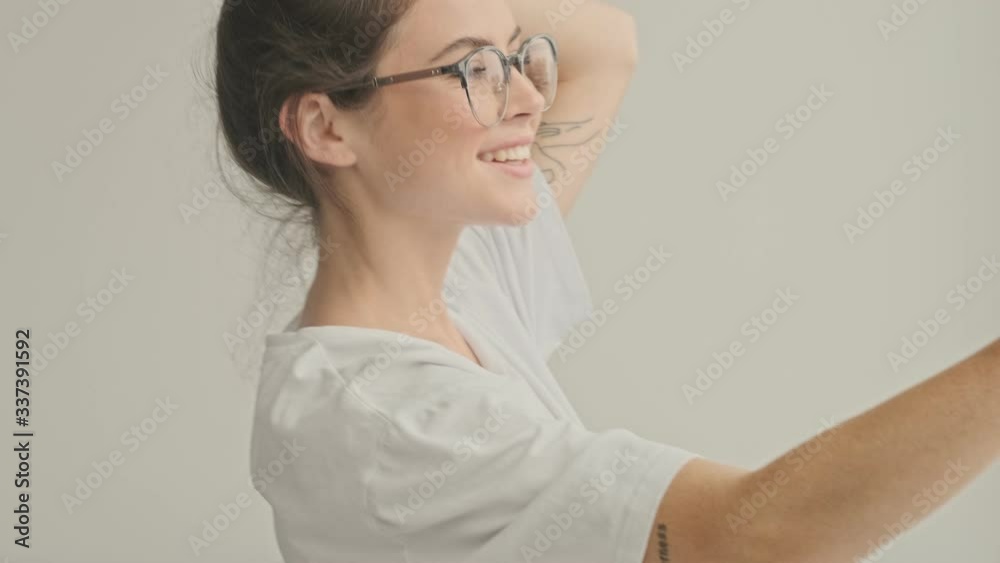 Poster happy pretty brunette woman in eyeglasses making selfie on smartphone at home