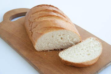 Sliced loaf of bread on a cutting board isolated on white background. Close up