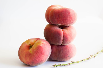 Flat peaches isolated on white background with dougnut peach branch in foreground