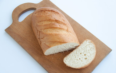Sliced loaf of bread on a cutting board. Isolated on white background. Close up