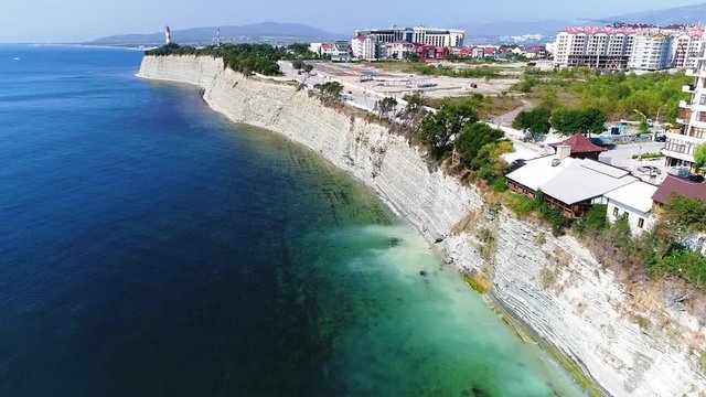 Rocky coastline with a cliff in Gelendzhik, Black sea. Drone flight over the coastline to the lighthouse. 