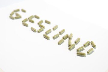 Health written with green pills (german, diagonal down)