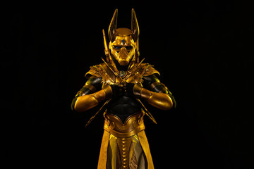 a male actor in a suit of an Egyptian mythology character, the golden deity Jackal Anubis, twists...