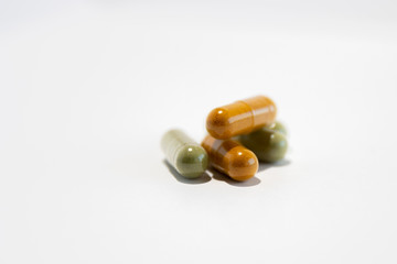 Five green and yellow pills (gel capsules with moringa and curcuma)