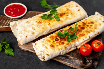 Burrito wraps with chicken and vegetables , against a background of concrete, 
 Mexican shawarma
