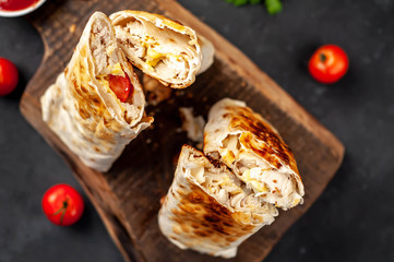 Burrito wraps with chicken and vegetables , against a background of concrete, 
 Mexican shawarma