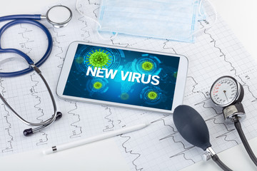 Close-up view of a tablet pc with NEW VIRUS inscription, microbiology concept