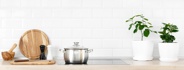 White modern kitchen interior with wooden worktop and kitchenware, culinary concept, background,...