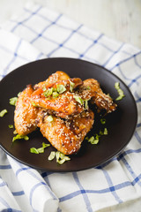 Crispy chicken wings with sesame seeds and chopped herbs