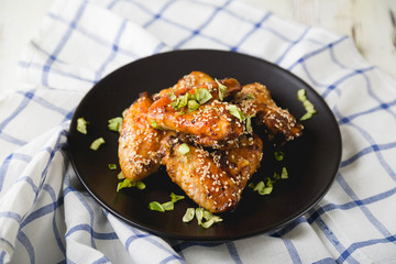 Crispy chicken wings with sesame seeds and chopped herbs